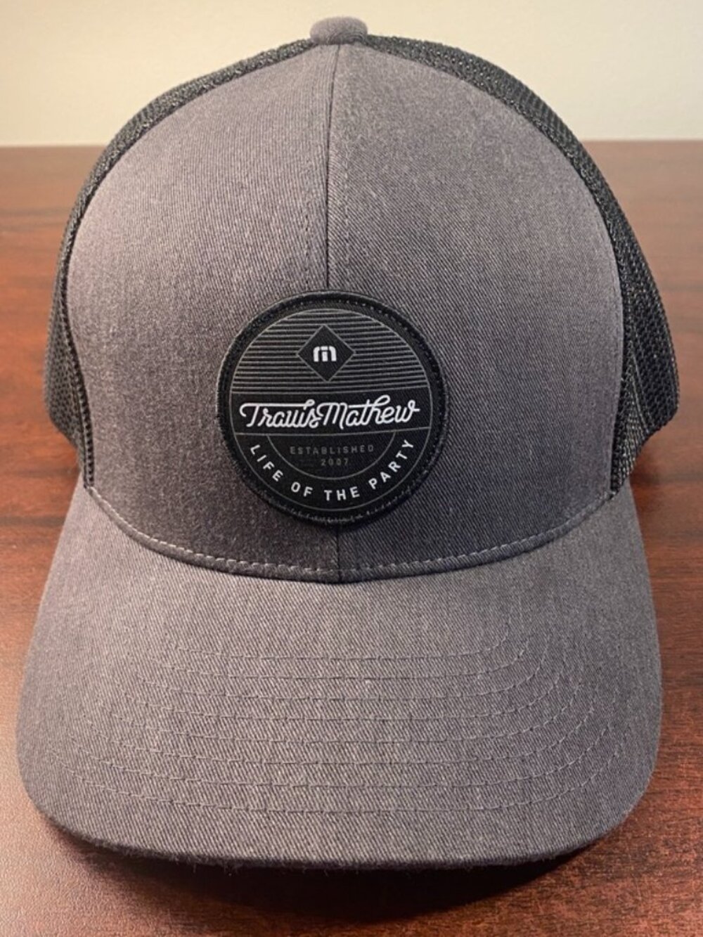 TravisMathew “Life of the Party” Trucker Hat in Gray/Black with Mesh